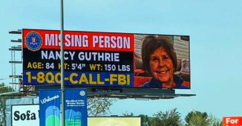 Nancy Guthrie missing person billboard showing photo and FBI tip line number.